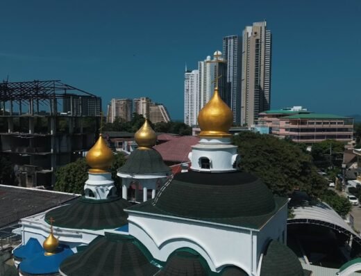 Золотые купола православного храма на фоне небоскребов в Паттайе